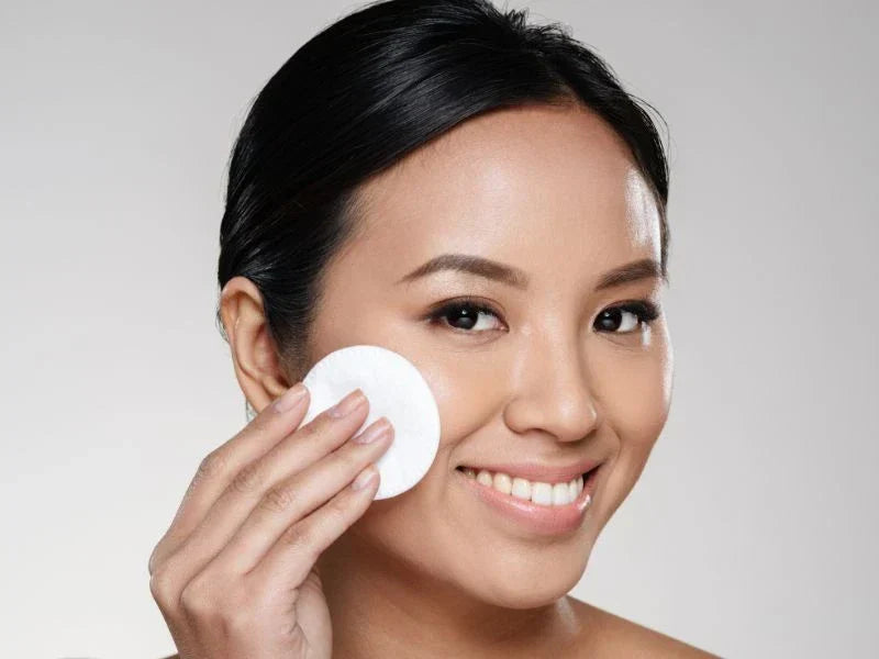 Beautiful lady cleaning her face with cotton pad