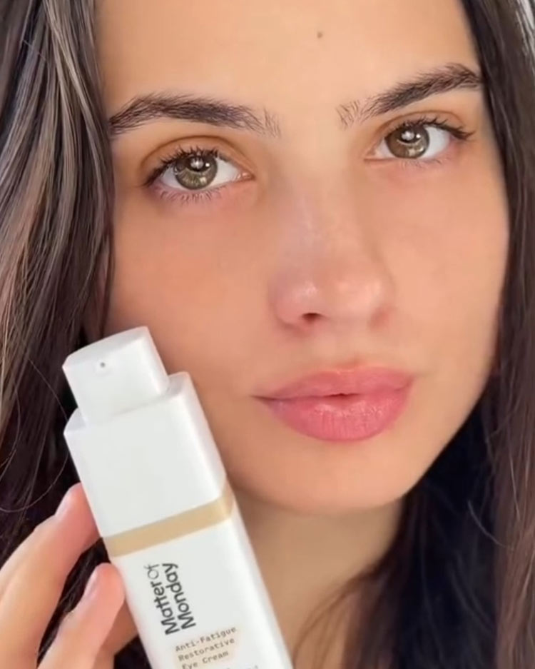 Woman holding a skincare product with a close-up of her face.