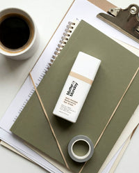 Eye cream on a notebook with a cup of coffee and a clipboard in the background