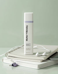 Matter of Monday skincare product on a light gray surface with a notebook and earbuds.