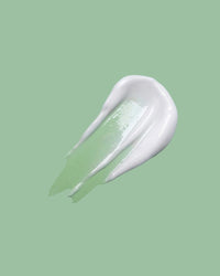 White cream smear on a light green background