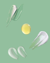 Yellow droplet surrounded by white and clear cosmetic products on a green background